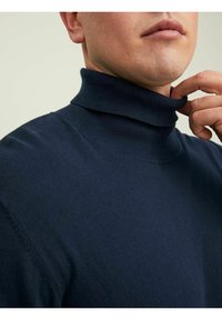 Maglione a collo alto blu navy realizzato in morbido tessuto texturizzato con dettagli a costine sul colletto e sui polsini, caratterizzato da un design aderente.