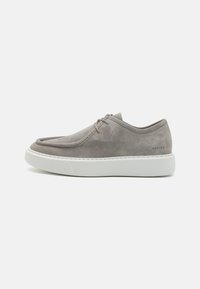 Grå ruskinnsneakers med avrundet tå og minimalistisk design. Har hvit gummisåle og subtile sømmer. Merke logo på hælen.