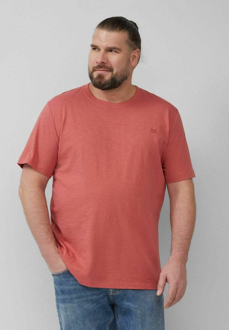 Kurze Ärmels T-Shirt mit Rundhalsausschnitt in Korallenfarbe, aus leichtem Material gefertigt, mit einem kleinen Logoakzent auf der linken Brust.