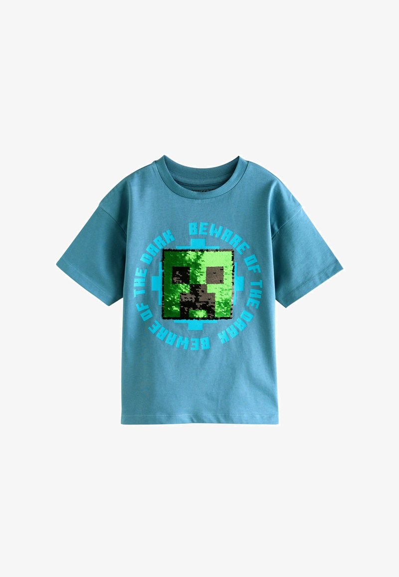 Blaues kurzärmeliges Hemd mit pixeligem grünen Monster-Gesicht und blauem Text mit der Aufschrift "Beware of the dark" in einem Kreis darum.