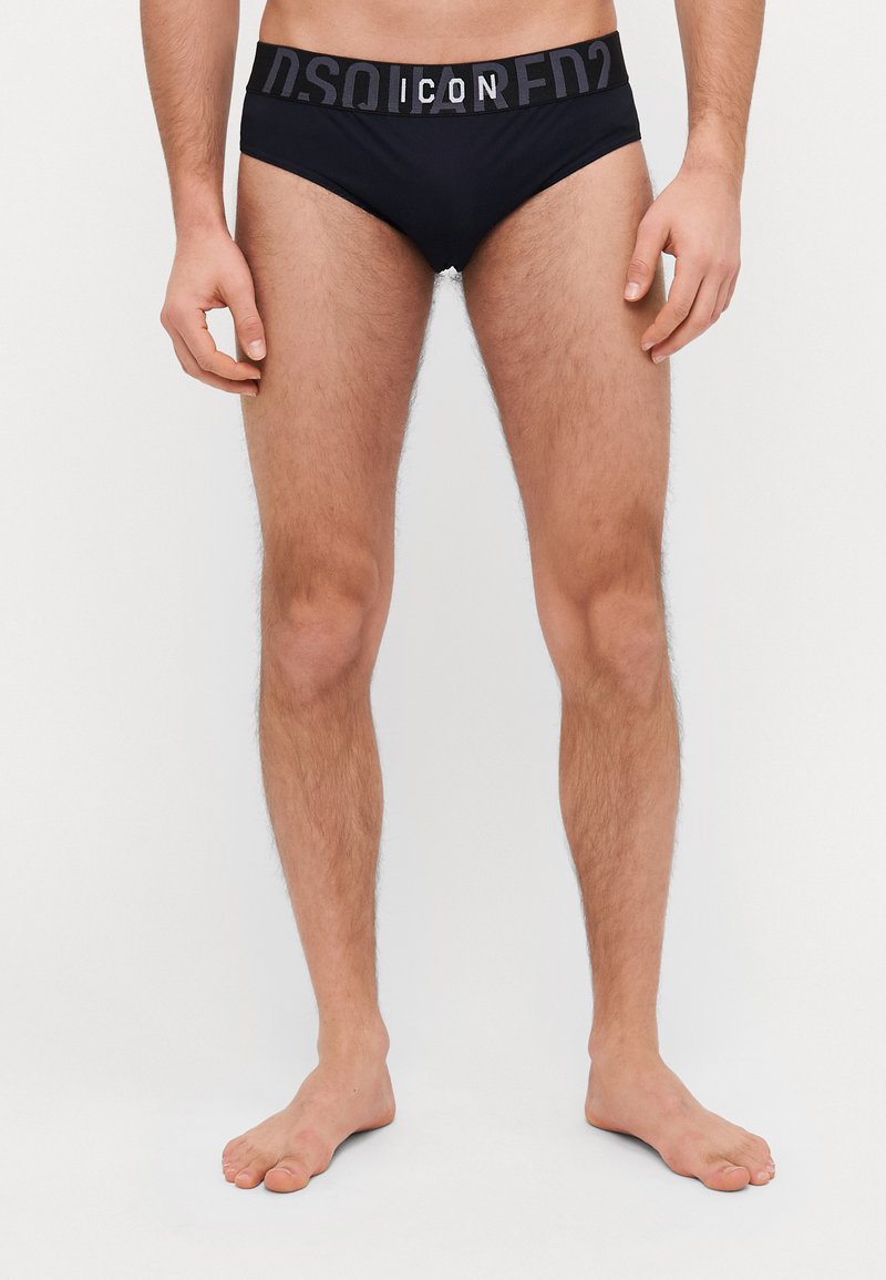 Schwarz Badebrieft mit einem kontrastierenden grauen elastischen Bund, der den Text "ICON" und "DSQUARED2" in großen Buchstaben trägt. Glatte Textur.
