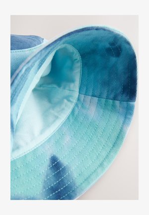 Sininen ja turkoosi lierihattu pehmeällä sisävuorella. Ominaisuuksiin kuuluu sileä pinta, leveä lieri ja liukuvärjätty kuvio. Näkyvä ompelu detailina.