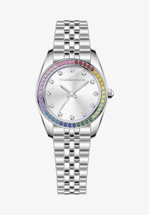 Hõbedatooniline kell, millel on ümmargune nägu, harjatud metallist kellaplaat ja bezel, mis on kaunistatud mitmevärviliste vääriskividega. Roostevabast terasest käevõru.