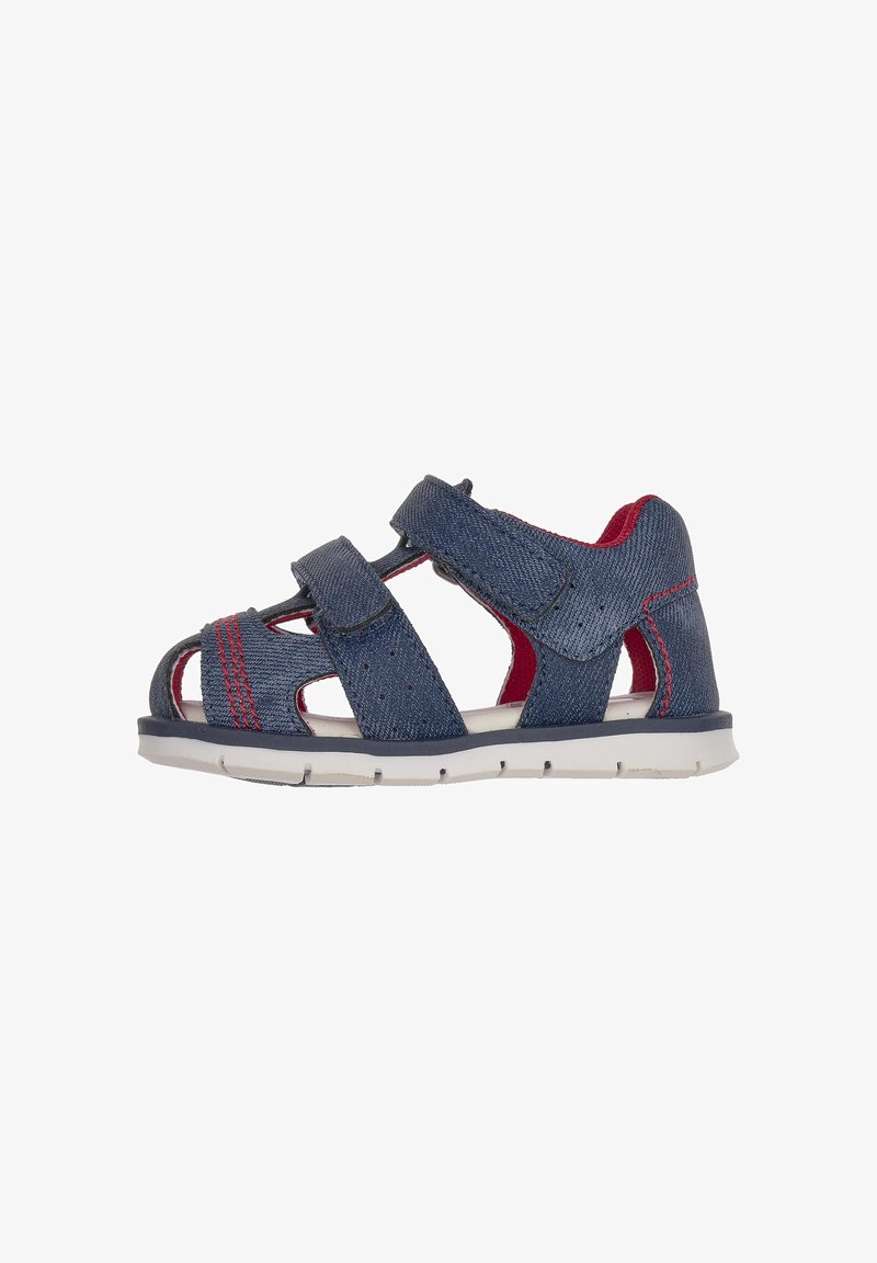 Navy blue sandal with denim texture, featuring two Velcro straps, open design, red accents, and a flexible white sole.