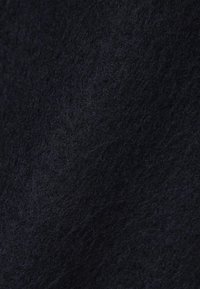 Tessuto in feltro blu navy con una superficie morbida e strutturata, che mostra un aspetto denso e soffice e lievi variazioni di colore e luce.