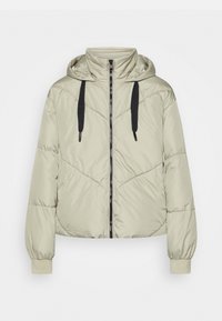 Donzen jas in lichtbeige met capuchon, voorzien van zwarte trekkoorden, een voorrits en elastische manchetten. Gestructureerd, doorgestikt ontwerp.