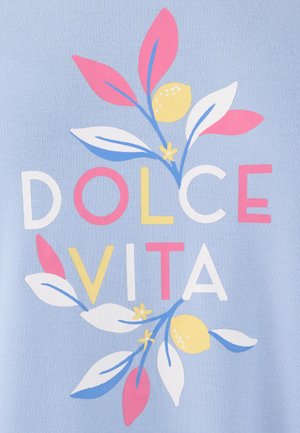 Texte « Dolce Vita » avec des feuilles roses, blanches, jaunes et bleues ainsi que des citrons sur un fond de tissu bleu clair.