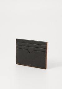 Portofel de carduri negru, fabricat din material texturat, cu cusături maro. Dispune de cinci sloturi pentru carduri, are o formă dreptunghiulară subțire și un design minimalist.