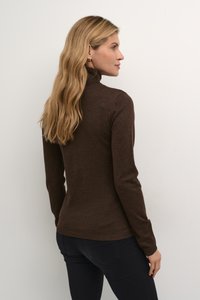 Barna garbó, puha kötött anyagból, hosszú ujjakkal, testhezálló fazonban, bordázott díszítéssel a mandzsettán és az alján.