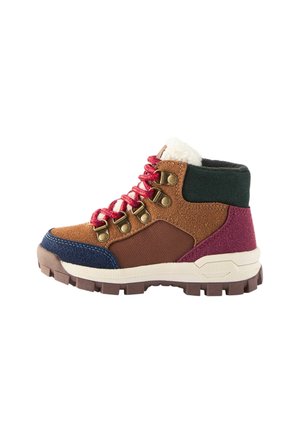 Chaussure de randonnée avec des panneaux marron, bleu marine, vert et bordeaux, des lacets rouges, des œillets en métal, une semelle épaisse et un col doublé en polaire blanche.