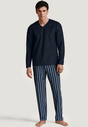 Haut navy à manches longues et col en V pour homme, associé à un pantalon de pyjama rayé bleu et blanc, fabriqué en tissu doux, offrant une coupe décontractée.