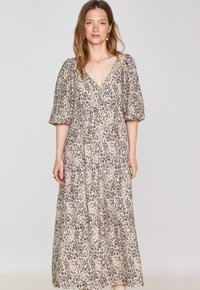 Robe maxi en tissu léger, dotée d'un motif léopard beige et noir, avec des manches bouffantes et un décolleté en V.