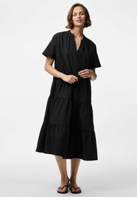 Must mustriba musta kleit kerge kangast, lühemate varrukatega, V-dekolteega ja kogutud vöökohaga, luues lõdva silueti.