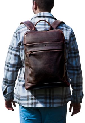 Zaino in pelle marrone con superficie liscia, forma rettangolare, tasca frontale con zip e doppie spalline, indossato da una persona.