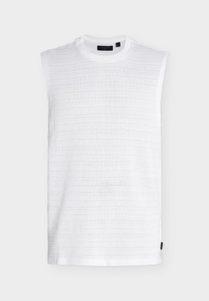 Haut en tricot blanc sans manches avec col rond, motif à rayures horizontales texturé et petite étiquette noire sur la couture latérale inférieure.