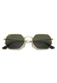 Occhiali da sole ottagonali in metallo dorato con lenti verde scuro. Presentano montature sottili e punte delle tempie marroni. Design minimale con un aspetto vintage.