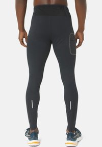 Black athletic leggings with a high waist, side pocket, and reflective zippers at the ankles. Made of stretchy, moisture-wicking fabric.