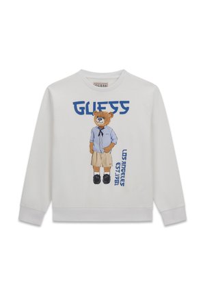 Felpa bianca con un orsacchiotto che indossa una maglietta blu, pantaloncini beige, scarpe nere e le scritte blu "GUESS" e "Los Angeles Est. 1981".