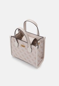 Lille beigefarvet håndtaske med brunt logo-mønster. Har to top håndtag, guldfarvet hardware og en struktureret form med kontrasterende trim.