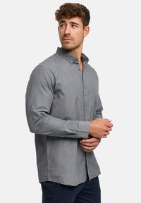 Harmaa pitkähihaiset nappipaita, kevyt kangas, kaulus, hienovarainen tekstuuri, etukappaleen läppä ja kalvosin yksityiskohdat. Sileä ja räätälöity istuvuus.