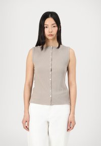 Haut beige sans manches en rib avec un col rond et une fermeture à boutons sur le devant, agrémenté de petits boutons blancs ; texture lisse.