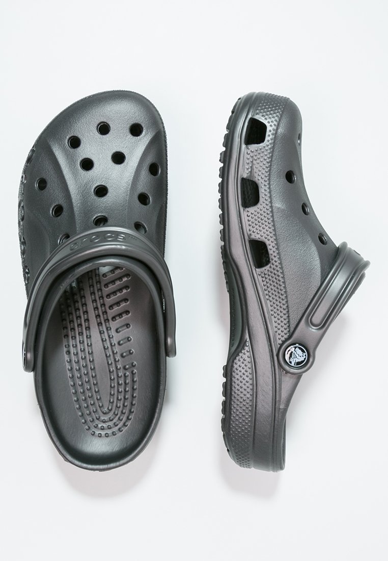 Zwarte rubberen klompen met ventilatiegaten, textuur in de zool en verstelbare hielband. Beschikt over een logo-accent aan de zijkant.