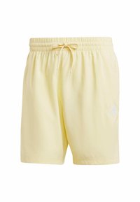 Ljusgula shorts med elastisk midja och dragsko. Har en vit logotyp på nedre högra sidan. Mjukt, lätt tyg.