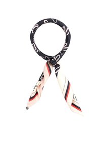 Foulard in seta nero e beige con motivi astratti bianchi e strisce rosse e nere, legato in un nodo sciolto con le estremità che pendono.