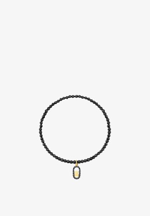 Pulsera elástica de cuentas negras con colgante ovalado de cristal negro que enmarca un pequeño charm de oso dorado.