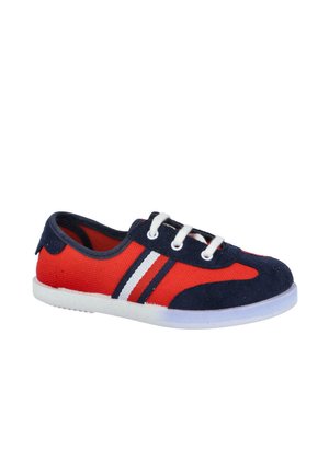 Zapatilla casual de perfil bajo con cuerpo de lona roja, puntera y talón de ante azul marino, cordones blancos y rayas blancas y azul marino en el lateral.