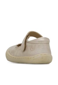 Zapato de cuero metálico pálido con diseño calado, correa ajustable y suela de goma con patrón de agarre texturizado. Elegante y funcional.