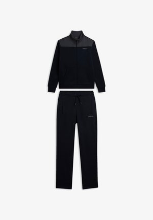 Chándal deportivo azul marino con chaqueta de cremallera que presenta un panel gris y bolsillos, combinado con pantalones a juego con cordón. Textura suave.