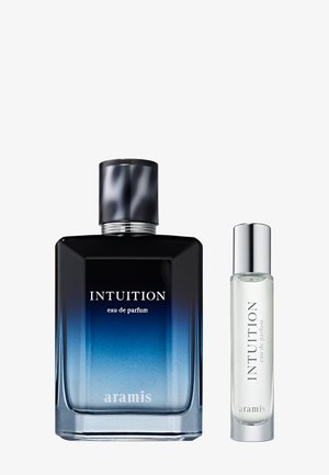 Deux flacons d'eau de parfum Aramis Intuition, un grand avec un verre dégradé bleu et un bouchon noir, un petit en verre transparent avec un bouchon argenté.