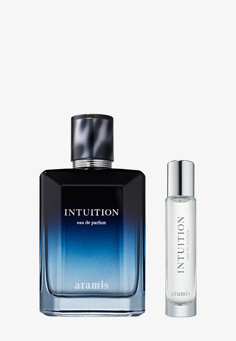 Deux flacons d'eau de parfum Aramis Intuition, un grand avec un verre dégradé bleu et un bouchon noir, un petit en verre transparent avec un bouchon argenté.