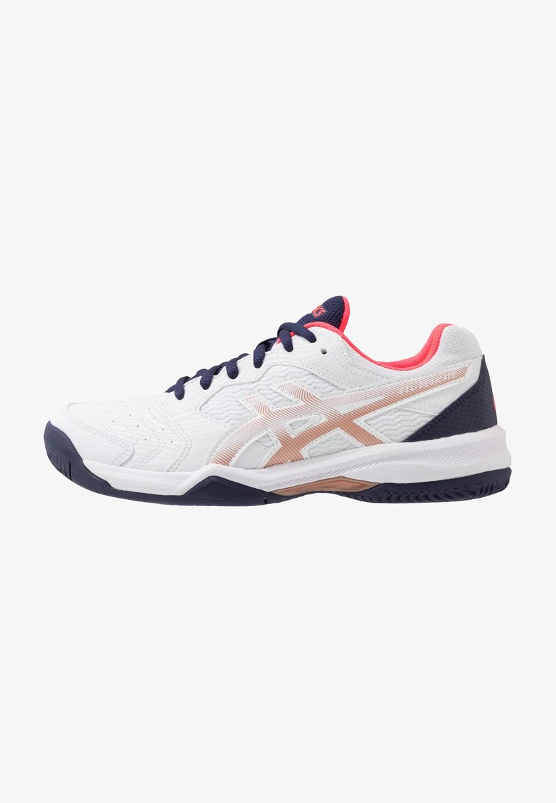White athletic shoe with textured upper, navy laces, and pink accents. Features a patterned sole and a metallic logo on the side.