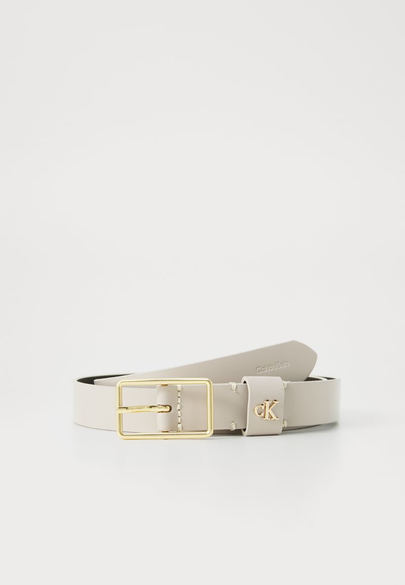Beiger Leder-Gürtel mit einer goldenen Schnalle, der über Stickdetails und ein kleines goldenes Logo-Element verfügt. Das Design ist flach und glatt.