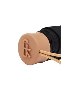 Czarny materiałowy uchwyt z brązowym gumowym końcem, z wytłoczonym logo i dwoma beżowymi elastycznymi linkami przymocowanymi dla lepszego uchwytu lub regulacji.