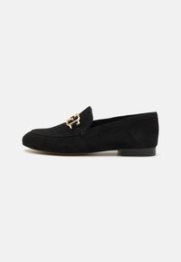 Mocassins en daim noir avec une boucle dorée, au design épuré, talon bas et texture lisse. Silhouette classique et polyvalente.