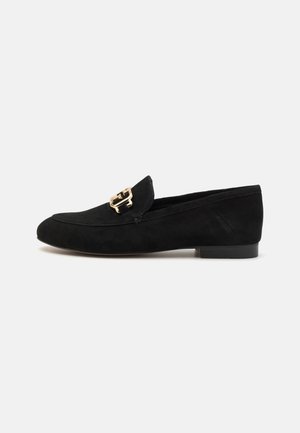 Mocassins en daim noir avec une boucle dorée, au design épuré, talon bas et texture lisse. Silhouette classique et polyvalente.