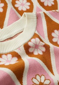 Strickpullover mit einem gerippten Kragen, verziert mit einem floralen Muster in Rosa und Weiß auf einem braun- und cremefarbenen Hintergrund. Weicher Stoff.