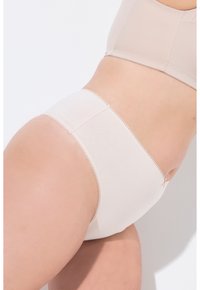 Culottes en coton beige avec une texture lisse, présentant des bords festonnés et un design sans coutures pour le confort. La vue de dos met en avant un style simple.