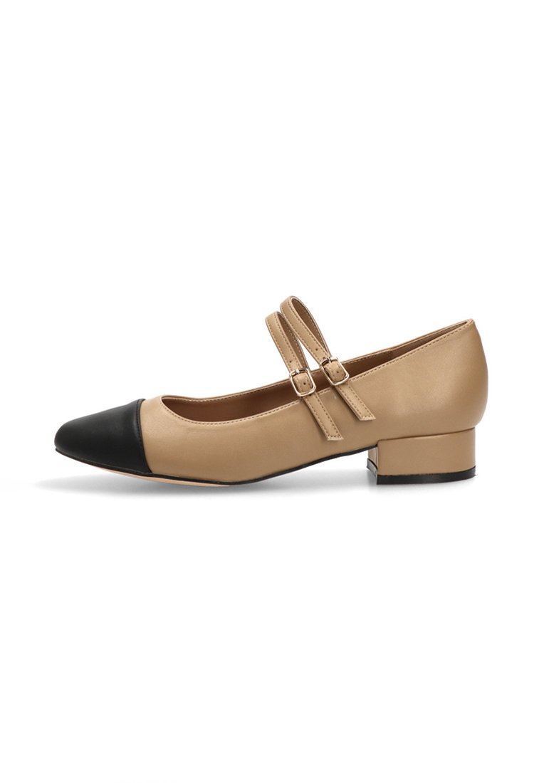 Bailarina de cuero beige con una puntera redonda negra, dos cintas ajustables y un tacón cuadrado bajo. Textura suave, detalles mínimos.
