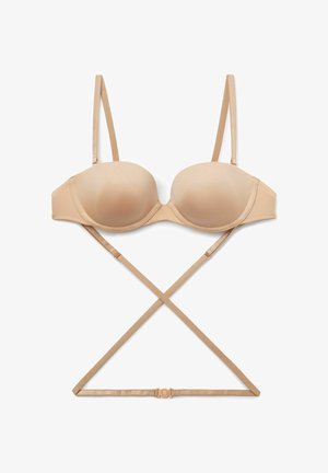 Beige molded bra with thin adjustable straps, underwire, and a cross-back design. Smooth texture with a hook-and-eye closure.
