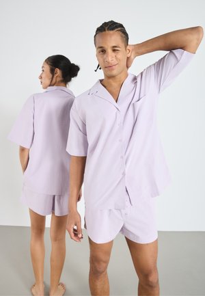Lavender short-sleeve shirt and shorts set in lightweight fabric, featuring a notch collar, button closure, and small pocket detail.