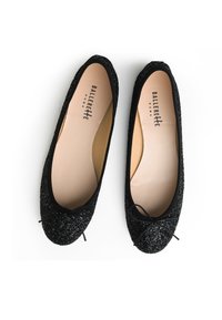 Ballerine nere realizzate in materiale scintillante, con punta rotonda, bordo elastico e un fiocco decorativo sul davanti.