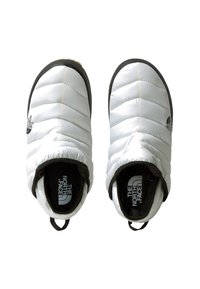 Bílé zateplené pantofle s prošívaným designem, černými gumovými podrážkami a s poutkem na zadní straně. Na boku mají logo The North Face.