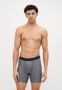 Boxeri gri dintr-un material elastic, cu un brâu elastic negru pe care este inscripționat textul "ARMOUR". Design ajustat, cu o textură fină.
