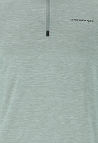 Lichtgroen atletisch shirt met korte mouwen en een halve rits kraag, met een textuurstof en het "ENDURANCE" logo in het zwart op de voorkant.