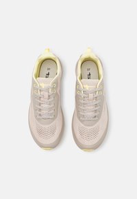 Beżowe buty sportowe z żółtymi akcentami, z siateczkowymi detalami zapewniającymi wentylację oraz szarymi sznurowadłami. Rozmiar 37, okrągły czubek, trwała podeszwa.