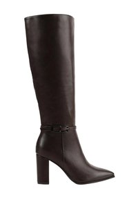 Botte en cuir marron foncé, montante jusqu'au genou, avec un bout pointu, une texture lisse et un accent décoratif de ceinture à la cheville. Talon épais et haut.